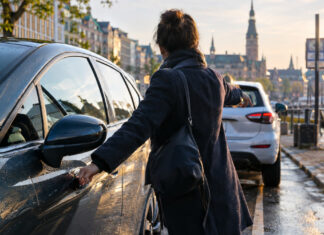 WunderCar gestartet Carsharing-Auto an einer Hamburger Ladezone, eine Hand am Türgriff, Morgenlicht