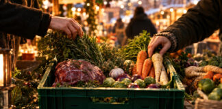 Hände packen Wintergemüse und Kräuter in eine Einkaufskiste auf dem Markt.