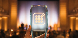 Hand hält gläsernen Pokal mit App-Symbol bei einer Preisverleihung