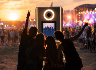 SelfieBox bei einem Event, Besucher posieren davor, warmes Abendlicht