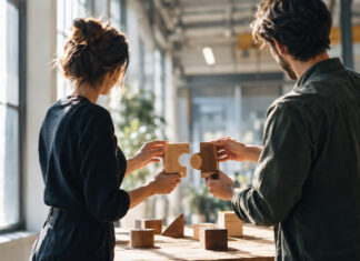 Zwei Gründer wählen in einer Industriehalle passende Holzbausteine aus