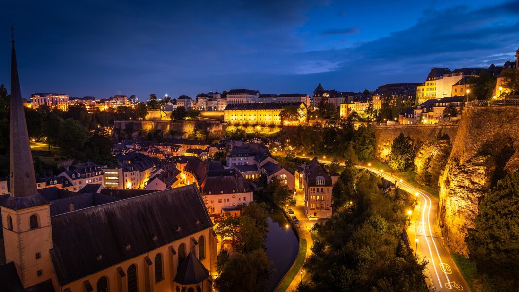 Das Viertel Grund in Luxemburg-Stadt zur blauen Stunde mit beleuchteter Altstadt und Festungsmauer