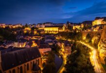 Auswandern nach Luxemburg: Anmeldung, Löhne, Mieten und Gründung Das Viertel Grund in Luxemburg-Stadt zur blauen Stunde mit beleuchteter Altstadt und Festungsmauer