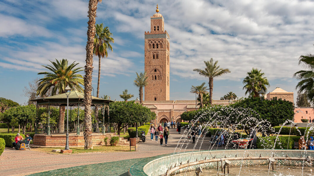 Auswandern nach Marokko: Aufenthalt, Steuern und Gründung Minarett der Koutoubia-Moschee in Marrakesch über Palmen, Park und Springbrunnen