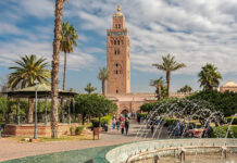 Auswandern nach Marokko: Aufenthalt, Steuern und Gründung Minarett der Koutoubia-Moschee in Marrakesch über Palmen, Park und Springbrunnen