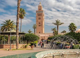 Auswandern nach Marokko: Aufenthalt, Steuern und Gründung Minarett der Koutoubia-Moschee in Marrakesch über Palmen, Park und Springbrunnen