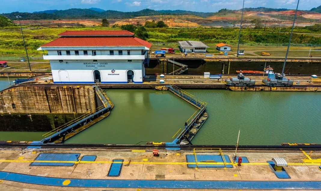 Blick auf die Miraflores-Schleuse des Panamakanals mit Schleusenkammer und Hügeln