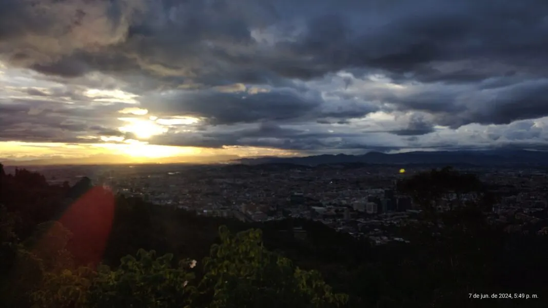 Blick von einem Hügel über Bogotá bei Sonnenuntergang mit Wolken über der Stadt