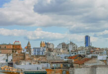 Blick über die Dächer von Tunis mit Kirchtürmen und einem blauen Hochhaus im Hintergrund