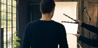 Gründer von hinten vor Filmklappe auf Studio-Set bei natürlichem Licht