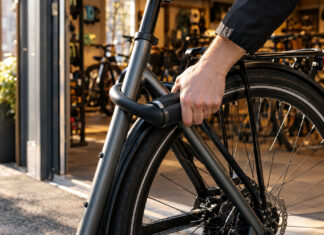 Fahrradschloss an einem Stadtfahrrad vor einem Fahrradladen im Tageslicht