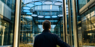 Gläsernes Innovationszentrum mit leuchtenden Modulen und einer Person am Zugangstor