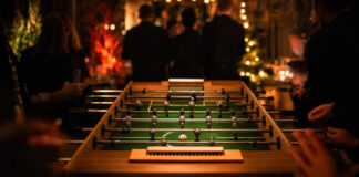 Kickerturnier bei einem Networking-Event am Abend mit Lichterketten und Silhouetten