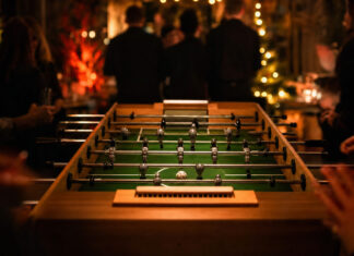Kickerturnier bei einem Networking-Event am Abend mit Lichterketten und Silhouetten