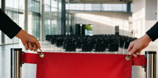 Leeres Banner am Messeeingang, daneben wartende Stühle in hellem Tageslicht.