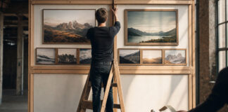 Gründer vor einer aufgebauten Website-Wand mit Förderstempel bei warmem Tageslicht