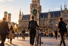 Gründerin mit Fahrrad am Marienplatz vor dem Münchner Rathaus im Abendlicht