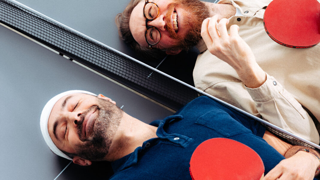 Höhle der Löwen Staffel 20, Folge 1 (DHDL): alle drei Deals Waldemar Zeiler und Kian Pariwar, die Gruender von Ding Dong Ping Pong, liegen mit Schlaegern auf einer Tischtennisplatte