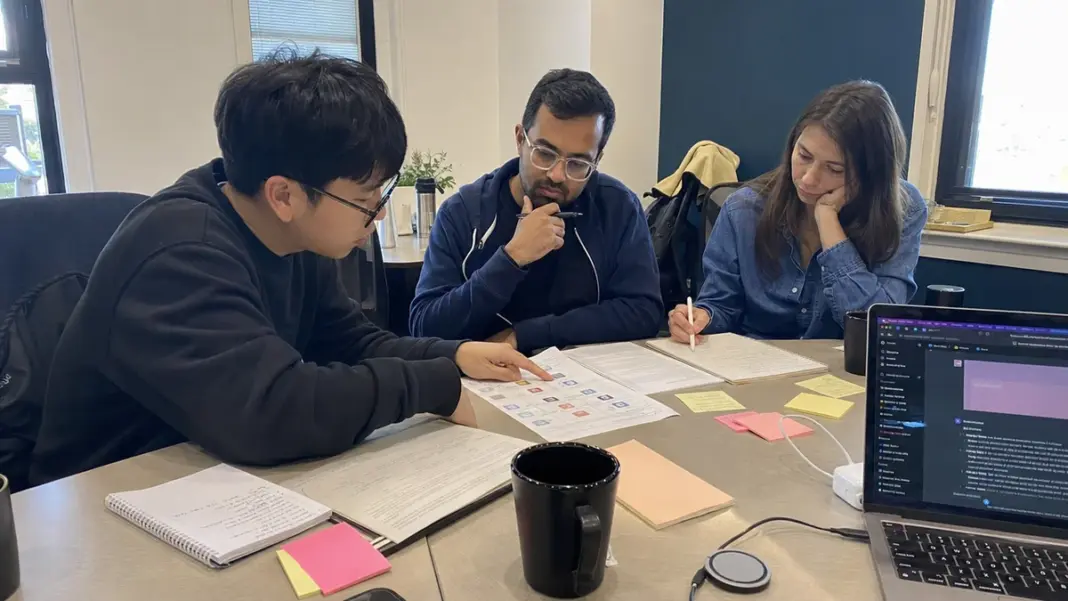 AI-Literacy-im-Startup Startup-Team bespricht KI-Regeln und Schulungsunterlagen an einem Meetingtisch.