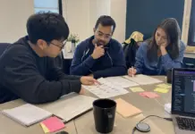 AI Literacy Unternehmen im Startup 2026: KI-Kompetenz im Team praxisnah aufbauen Startup-Team bespricht KI-Regeln und Schulungsunterlagen an einem Meetingtisch.