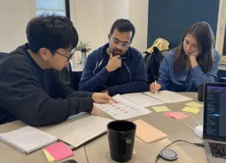 Startup-Team bespricht KI-Regeln und Schulungsunterlagen an einem Meetingtisch.