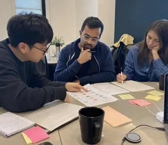 Startup-Team bespricht KI-Regeln und Schulungsunterlagen an einem Meetingtisch.