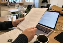 Auftragsverarbeitungsvertrag SaaS: Wann dein Startup wirklich einen AVV braucht Hände prüfen einen AVV und Datenschutzunterlagen auf einem Schreibtisch.