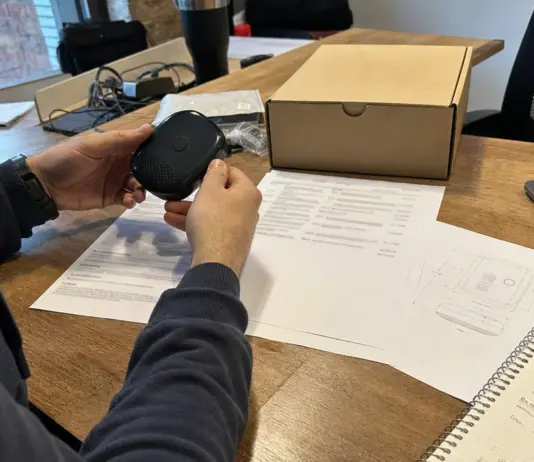 Startup-Team prüft Produktunterlagen und ein Elektronikgerät für die CE-Kennzeichnung.