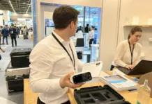 Startup-Team bereitet eine Produktdemo am German Pavilion auf einer internationalen Messe vor.