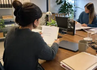Mitarbeiterin prüft Unterlagen für die Einstellung internationaler Fachkräfte im Startup.