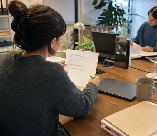 Mitarbeiterin prüft Unterlagen für die Einstellung internationaler Fachkräfte im Startup.