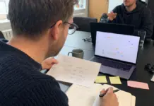 KI-Agenten einsetzen: Der praxisnahe Startup-Check 2026 Gründerin prüft einen KI-Agenten-Workflow mit Checkliste und Laptop im Startup-Büro.