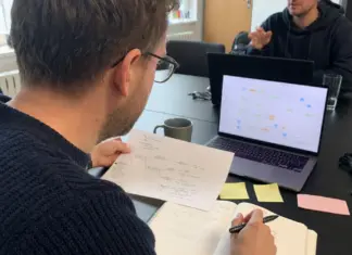 Gründerin prüft einen KI-Agenten-Workflow mit Checkliste und Laptop im Startup-Büro.