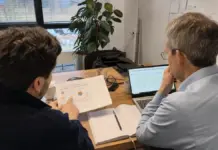 Zwei Mitarbeitende planen einen messbaren KI-Piloten an einem Besprechungstisch.