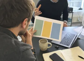 Mitarbeitende prüfen eine KI-Richtlinie mit Daten- und Freigaberegeln im Startup-Büro.