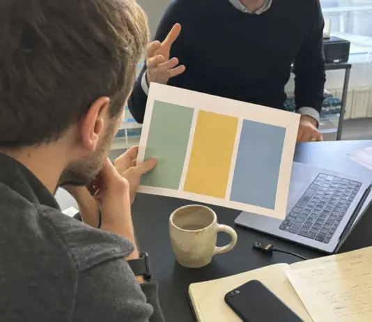 Mitarbeitende prüfen eine KI-Richtlinie mit Daten- und Freigaberegeln im Startup-Büro.