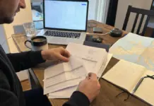 Unternehmerin prüft Unterlagen für eine EU-Rechnung mit USt-ID am Schreibtisch.