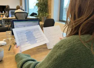 Gründerin prüft Fundraising-Unterlagen und Marktkennzahlen am Arbeitsplatz.