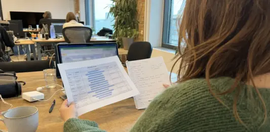 Gründerin prüft Fundraising-Unterlagen und Marktkennzahlen am Arbeitsplatz.