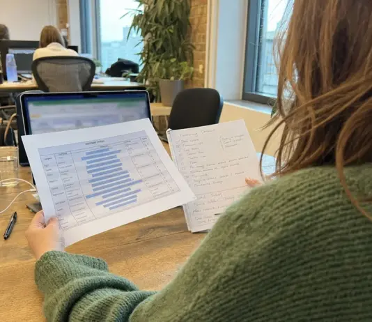 Gründerin prüft Fundraising-Unterlagen und Marktkennzahlen am Arbeitsplatz.