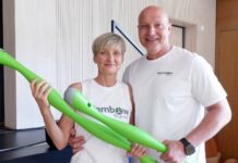 Die Ajambow-Gründer Susan Schmidt und Simon Werner halten je einen grünen, wassergefüllten Ajambow-Bogen