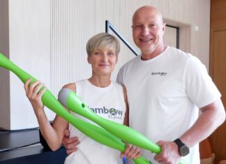 Die Ajambow-Gründer Susan Schmidt und Simon Werner halten je einen grünen, wassergefüllten Ajambow-Bogen