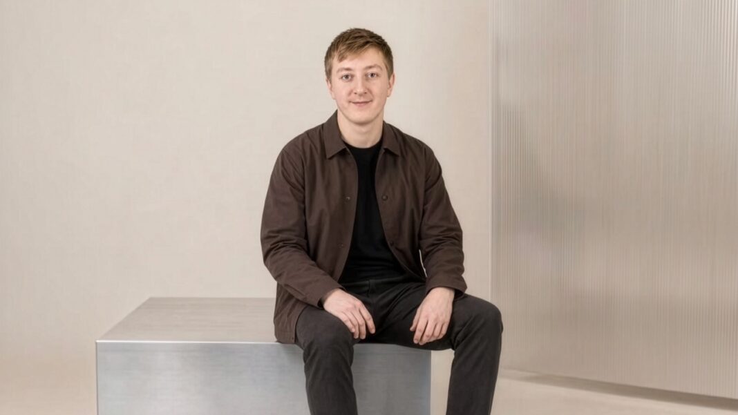 Moritz Zinecker, Gründer von Audecius und Clarity Moritz Zinecker, Gründer von Audecius, sitzt in brauner Jacke auf einem Metallblock vor heller Wand