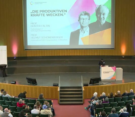 Blick in das Audimax der Freien Universität Berlin beim Entrepreneurship Summit 2026, vorn die Bühne mit der Leinwand, im Saal das Publikum