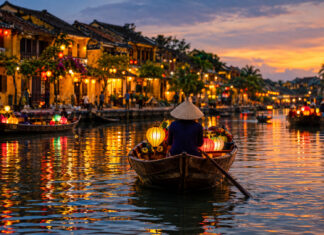 Die Altstadt von Hoi An in Vietnam am Abend mit Laternen, gelben Kaufmannshäusern und Booten auf dem Fluss Thu Bon