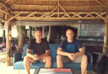 Die blookery-Gründer Kevin Kiesewetter und Jannis Jäger sitzen auf einem Sofa unter einem Bambusdach