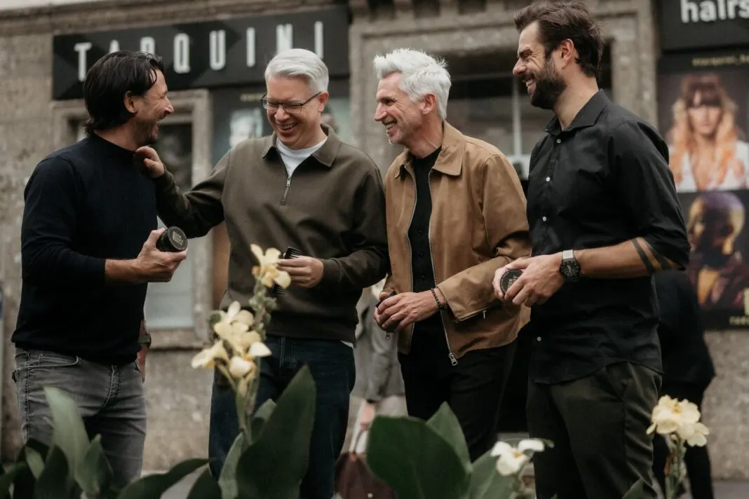 Die drei Don-Quiff-Gründer und Investor Frank Thelen stehen lachend mit Haarwachs-Dosen vor dem Friseursalon Tarquini in Salzburg