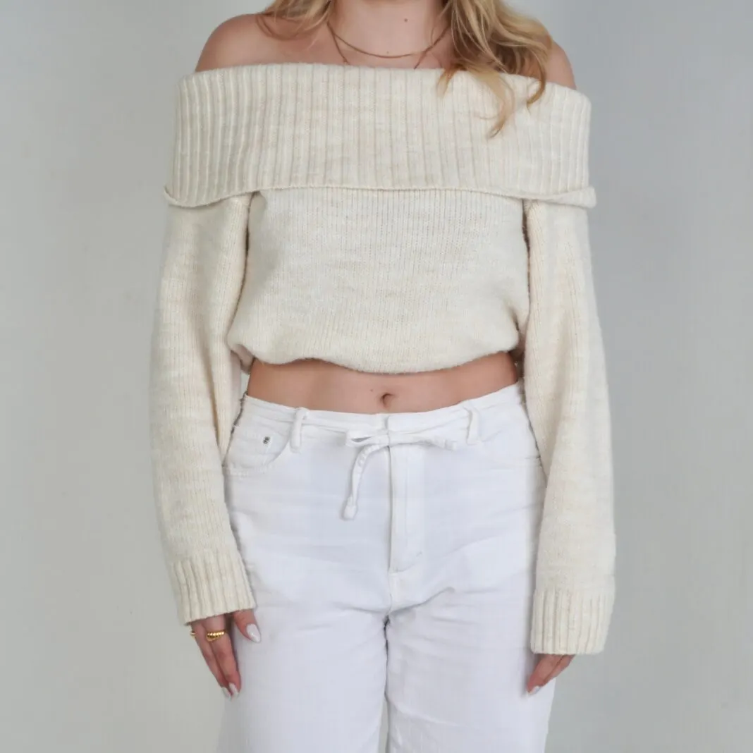 Heller Oversize-Pullover, der mit dem Crop-Band auf Taillenhoehe gekuerzt getragen wird
