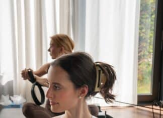 Frau mit zusammengestecktem Haar traegt eine helle ivyclip-Haarklammer waehrend einer Pilates-Uebung
