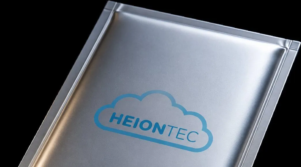 Eine silberne Pouchzelle mit HEIONTEC-Logo vor schwarzem Hintergrund